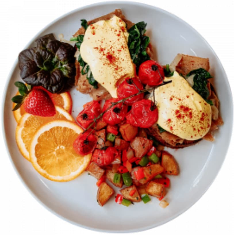 Plate of Black Forest Seitan "Eggs" Benedict, roasted potatoes and roasted tomatoes from Mean Greens Café.